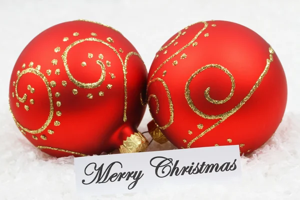 Merry Christmas card met rode kerstballen, op besneeuwde ondergrond — Stockfoto