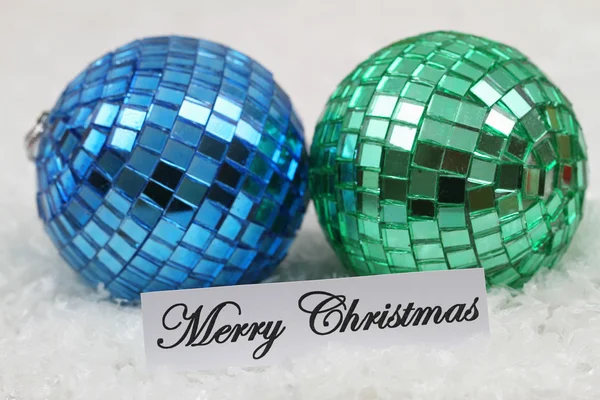 Joyeux Noël carte avec des boules bleues et vertes, sur la surface enneigée — Photo