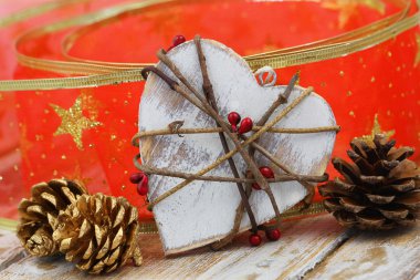 Ahşap kalp, altın çam kozalakları ve kırmızı Noel şerit