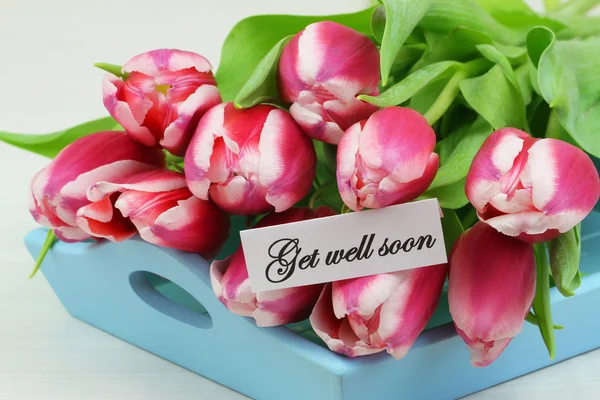 Bonne carte avec tulipes roses sur plateau bleu — Photo