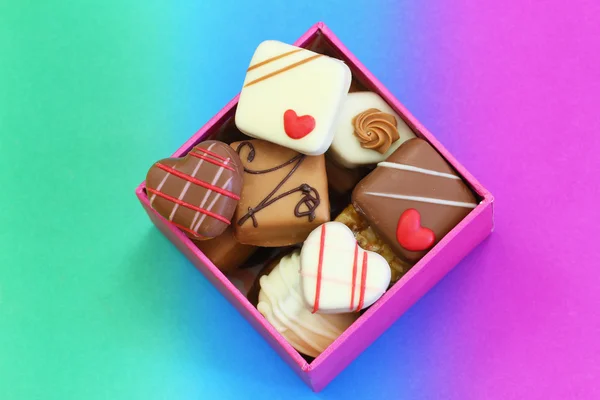 Assorted chocolates in box on colorful background — Stock Photo, Image