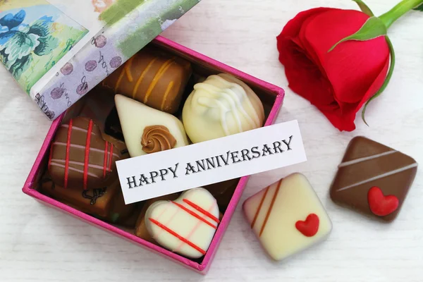 Happy Anniversary card with chocolates and red rose — Stock Photo, Image