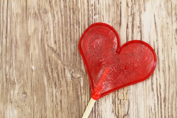 Heart shaped lollipop on wooden surface with copy space — Stock Photo, Image