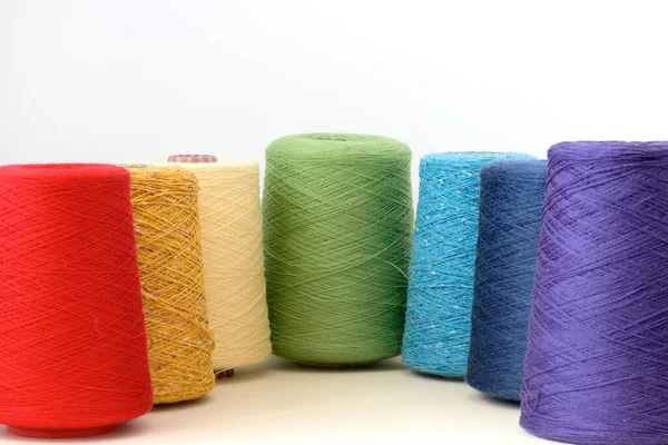 Carretéis de fios de lã de cores arco-íris para mão e máquina de tricô em um fundo branco — Fotografia de Stock