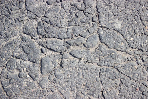 Fundo áspero pedra dobras preto sujo asfalto — Fotografia de Stock