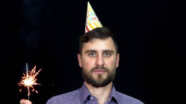 Şenlik şapkalı bir adam elinde Bingala ateşi tutuyor. Doğum günü partisi 4k