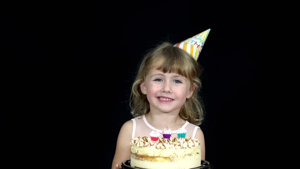 Mädchen Mit Geburtstagskappe Bläst Die Kerzen Auf Der Torte Aus — Stockfoto