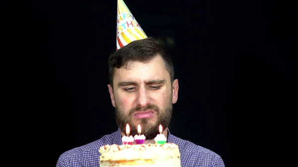 Trauriger Mann Mit Geburtstagstorte Bläst Kerzen Auf Schwarzem Hintergrund Aus — Stockfoto
