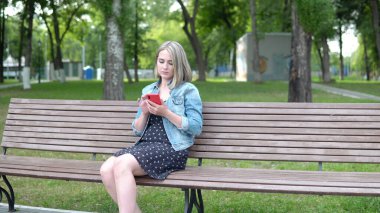 Banktaki kadın akıllı telefon 4K kullanıyor.