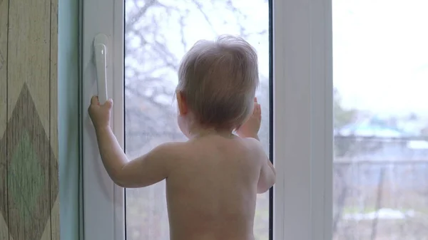 Barnet Står Framför Fönstret Och Knackar Glaset Med Handflatan — Stockfoto