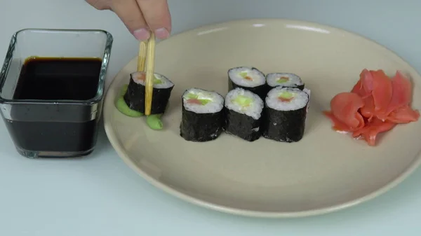 Sushi Steso Piatto Bacchette Prendono Sushi Immergono Nella Salsa Soia — Foto Stock