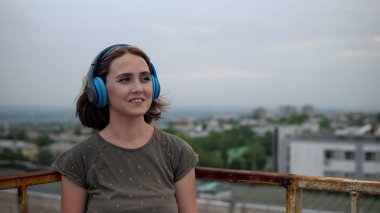 Kadın kulaklık takar ve iyi bir ruh haline bürünür.