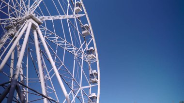 Parkta, büyük bir dönme dolap yavaşça dönüyor. Yüksek irtifa görünüm tekerleği 4k