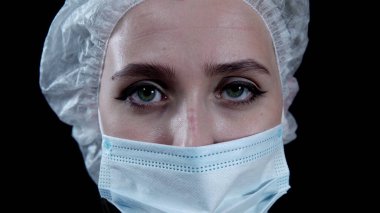 Tired nurse looking at camera on black background 4k clipart