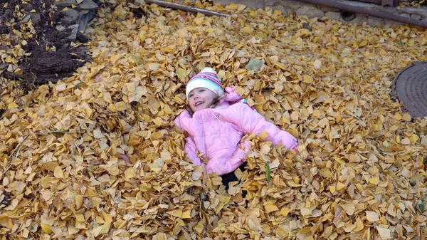 Menina Está Uma Pilha Folhas Caídas Faz Anjo Outono Jarda — Fotografia de Stock