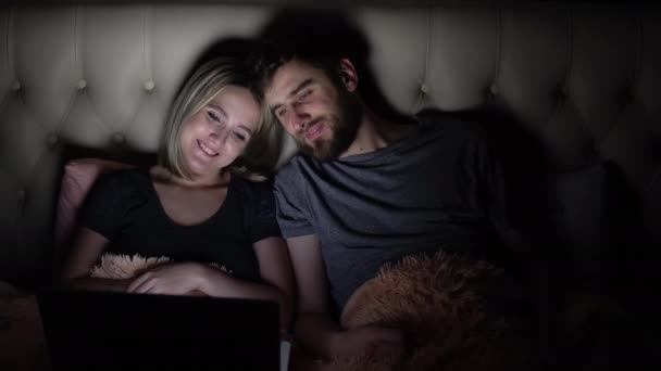 Pria dan wanita, pasangan muda menonton film romantis di laptop di tempat tidur sebelum tidur — Stok Video