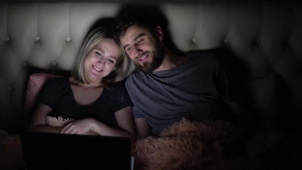 Pria dan wanita, pasangan muda menonton film romantis di laptop di tempat tidur sebelum tidur — Stok Video