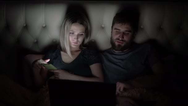 Hombre y mujer, pareja joven viendo película aburrida en el ordenador portátil en la cama antes de acostarse — Vídeos de Stock