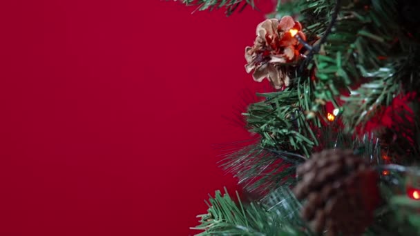 Hart van een kerstspeelgoed opgehangen aan een kerstboom op een rode achtergrond close-up — Stockvideo