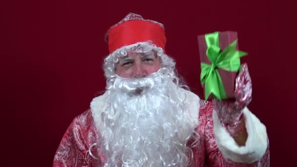 Rus Noel Baba elinde bir Noel hediyesi tutuyor ve baş parmağını kaldırıyor. — Stok video