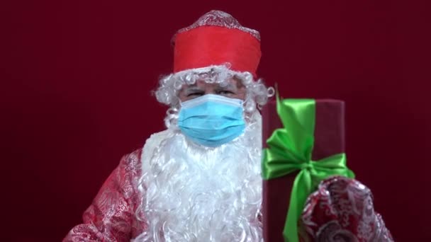 Papá Noel ruso sostiene un regalo de Navidad en su mano y lo llama para presentarlo — Vídeo de stock
