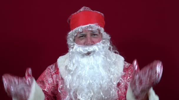 Papai Noel russo em um fundo vermelho espalhou suas mãos em que não há presentes e encolheu os ombros — Vídeo de Stock