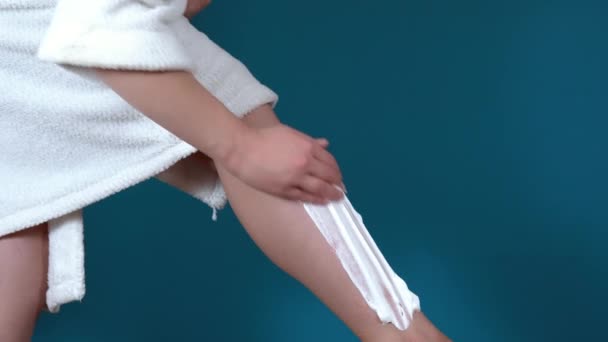Close-up van benen van een jonge vrouw. Scheerbenen met scheerschuim en een handscheermes — Stockvideo