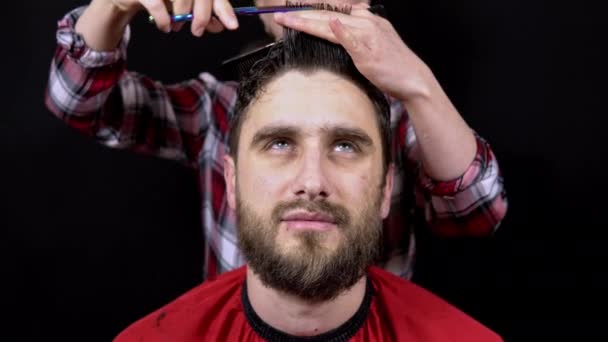 Muž v kadeřnickém salonu žena mistr stříhá její vlasy na černém pozadí — Stock video