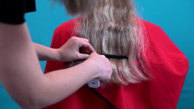 Kuafördeki bir kadın için, kuaför saçının uzunluğunu kısaltır.