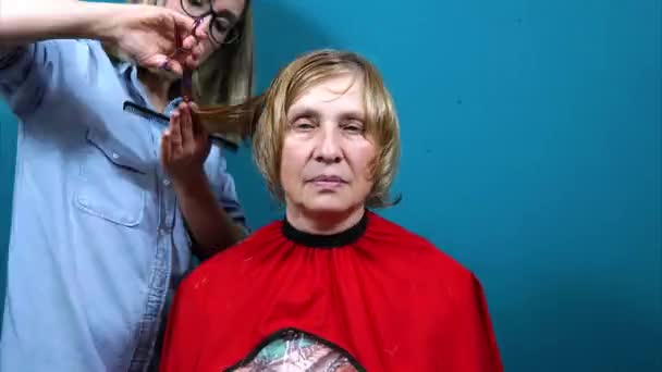 Időszakos lövöldözés. Női fodrász vágja a nők haját otthon, a szalonban, a gyors mozgás — Stock videók