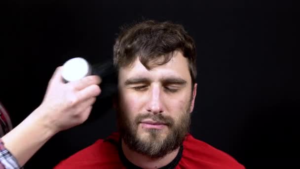 La peluquera cepilla el cabello cortado de la cara del hombre con un cepillo especial — Vídeos de Stock