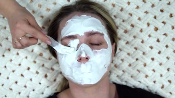 Een witte alginaat masker wordt toegepast op een vrouw om haar huid te verjongen. — Stockvideo