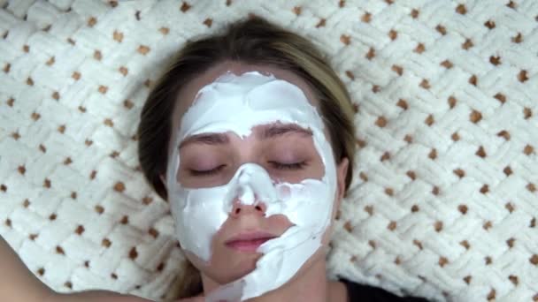 Een witte alginaat masker wordt toegepast op een vrouw om haar huid te verjongen. — Stockvideo