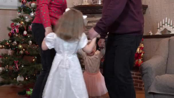 Familia cogida de la mano en un círculo de baile para Navidad. Los abuelos y las nietas celebran un nuevo año 4k — Vídeos de Stock