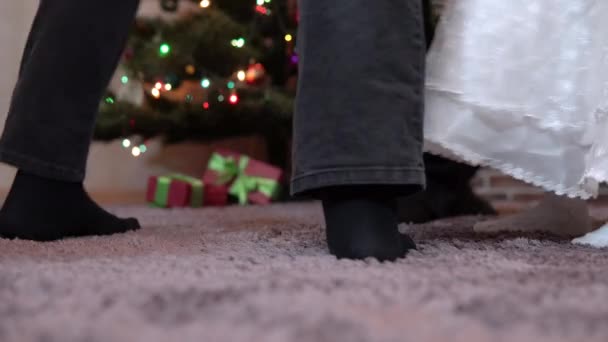 Zbliżenie nogi rodziny krążącej wokół okrągłego tańca na Boże Narodzenie na choince. Dziadkowie i wnuczki świętują Nowy Rok — Wideo stockowe