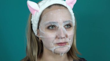 Kozmetik nemlendirici yüz maskesi takan kadının yüzü 4K 'ya yakın.