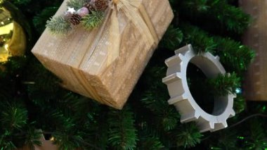 Büyük toplar, vitesler ve mühürlü hediyelerle süslenmiş büyük bir Noel ağacı. Yakın çekim kamera geçidi.