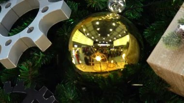 Büyük toplar, vitesler ve mühürlü hediyelerle süslenmiş büyük bir Noel ağacı. Yakın çekim kamera geçidi.