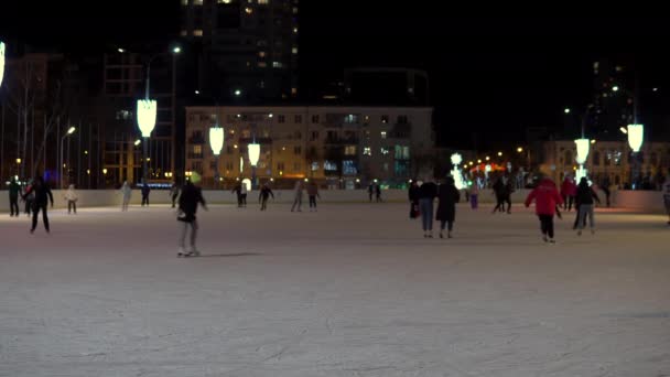 Folk åker skridskor på ishallen. Vintern i Ryssland, folk på rinken på kvällen — Stockvideo