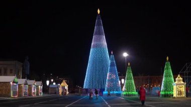 Akşam Rusya, Samara, Kuibyshev Meydanı, Yeni Yıl ağaçları tamamen ampullerle süslenmiş farklı desenlerle parıldıyor ve insanlar yürüyor