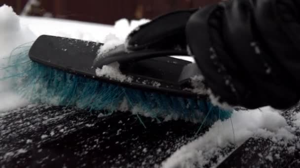 Eine Nahaufnahme einer Schneebürste räumt Schnee weg. Winter in Russland, das Auto war mit Schnee bedeckt — Stockvideo