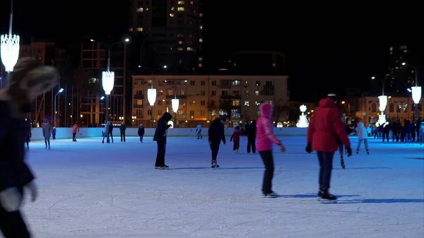 People are skating on the ice rink. Winter in Russia, people in the evening at the skating rink time-lapse video 4k