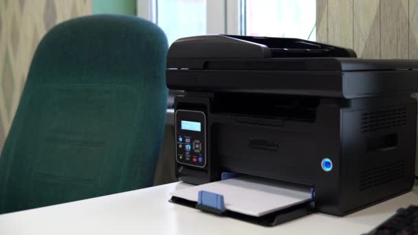 A impressora na mesa digitou uma palavra Olá em um pedaço de papel. Espaço de escritório, mesa, cadeira e impressora — Vídeo de Stock