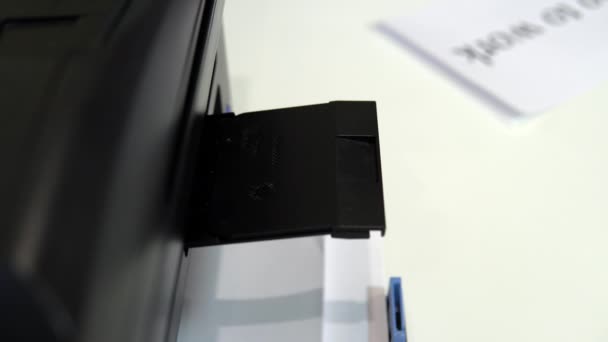 Принтер на столе напечатал мигающее улыбающееся лицо на листе бумаги — стоковое видео