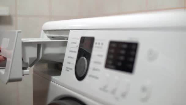 Fille charge la poudre à laver dans le gros plan de la machine à laver — Video
