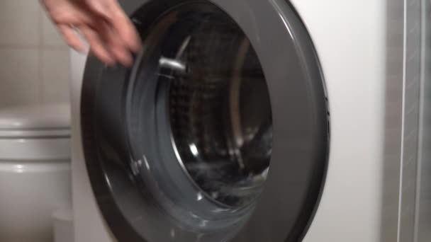Chica carga cosas sucias en la lavadora de cerca — Vídeo de stock