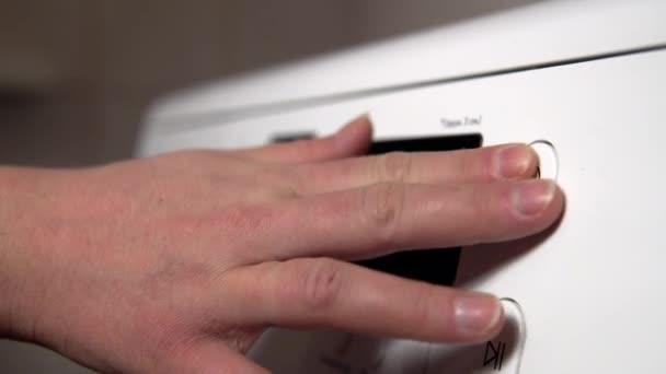 Крупный план женской руки включает программу стирки на стиральной машине — стоковое видео