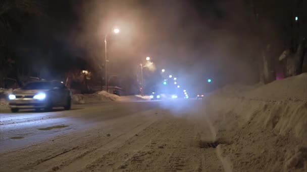 时间飞逝的射击俄罗斯冬季道路在晚上。水蒸气从路上的下水道炉栅里冒了出来 — 图库视频影像