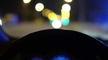 Direksiyonun arkasından yakın çekim görüntüsü, yolda arabaların ön camın arkasında sürüşü.