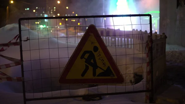 Het voetgangersgebied wordt gerenoveerd en er is een omheining en een verkeersbord geïnstalleerd. Stoom gaat achter het hek in de reparatieruimte — Stockfoto